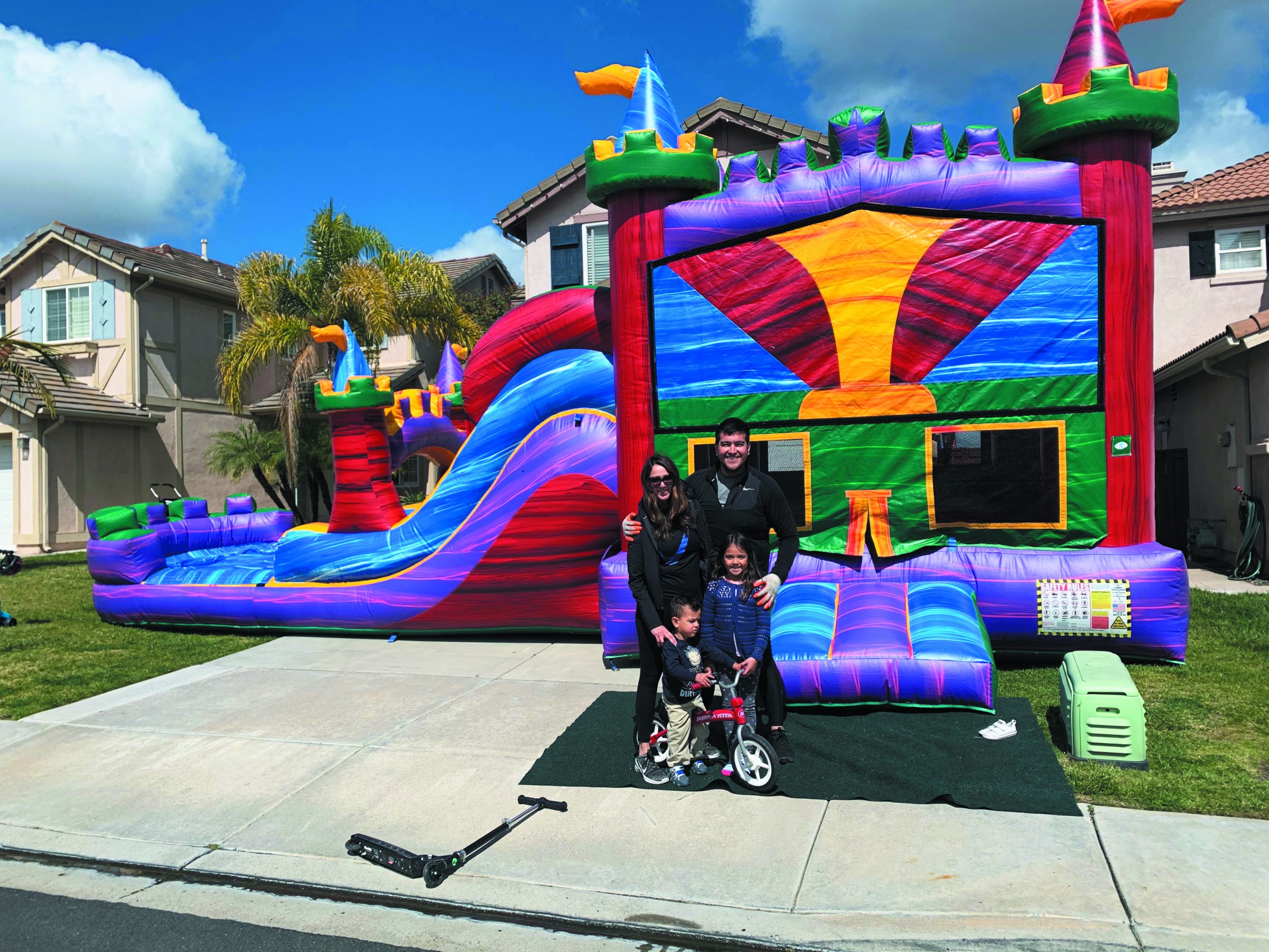 Alberto Frias, owner of Blue Bear Entertainment, poses in front of one of his company's colorful bounce houses.